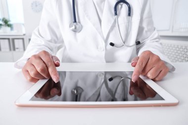 Klinikteki masada tabletli doktor, yakın çekim.