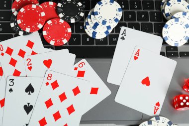 Çevrimiçi poker. Masada kart, fiş, zar ve dizüstü bilgisayar oynanıyor