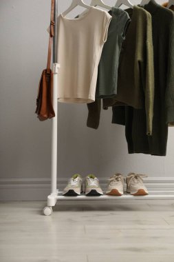 Aydınlık duvarın yanında giysi ve ayakkabılarla dizilin.