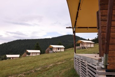 Yeşil orman ve dağlarda birçok ev. Glamping alanı