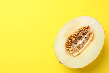 Sarı arka planda taze kavunun yarısı, üst manzara. Metin için boşluk
