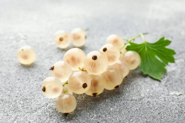 Gri desenli masada taze üzümler ve yeşil yaprak, yakın plan.