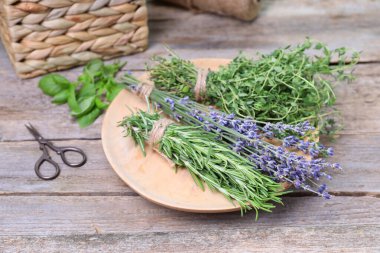 Ahşap masada değişik aromatik otlar ve makas.