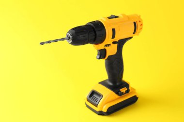 Sarı zemin üzerinde modern kablosuz elektrik matkabı