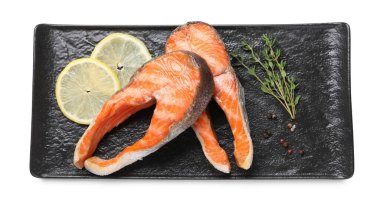 Lezzetli ızgara somon bifteği, limon ve baharatlar beyaza izole edilmiş.