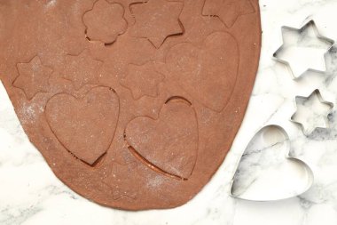 Çikolata hamuru ve kurabiye keskisi beyaz mermer masada, düz yatıyordu.