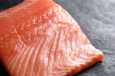 Karanlık masadaki taze somon parçası, yakın plan.