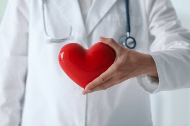 Klinikte kırmızı kalpli bir doktor, yakın plan.