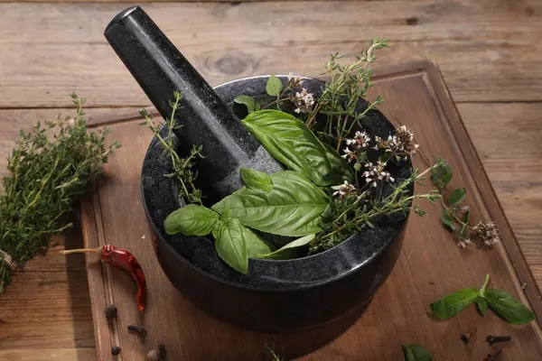 Tahta masada değişik aromalı otlarla havan topu.