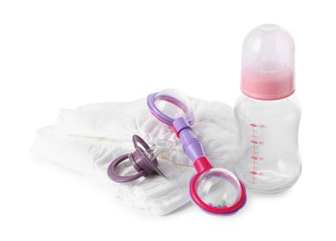 Renkli çıngırak, bebek bezi, şişe ve emzik beyaza izole edilmiş. Bebek eşyaları.