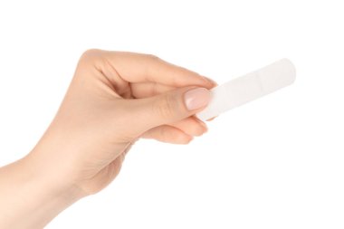 Beyaz arka planda tıbbi yapışkan bandaj tutan kadın, yakın plan.