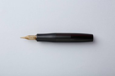 Açık gri arka planda profesyonel kalıcı makyaj makinesi, üst görünüm