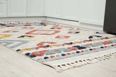 Mutfakta ahşap zeminde zarif yumuşak halı, yakın plan.