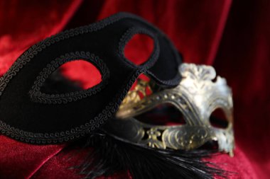 Kırmızı ipek kumaşta güzel karnaval maskeleri, yakın plan.