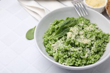 Parmesan peynirli lezzetli ıspanaklı risotto beyaz fayanslı masada servis edilir, yakın plan. Metin için boşluk