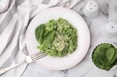 Beyaz mermer masada servis edilen lezzetli ıspanaklı risotto.