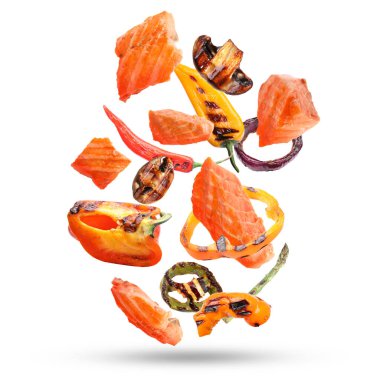 Lezzetli ızgara somon ve beyaz arka plana düşen sebzeler.