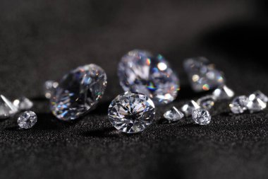 Many beautiful shiny diamonds on black fabric, closeup clipart