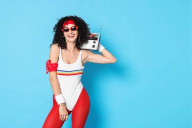 Aerobik. Açık mavi arkaplanda radyo alıcısı olan mutlu kadın, metin için boşluk