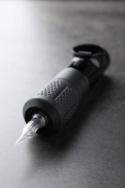 Gri arkaplanda profesyonel kalıcı makyaj makinesi, yakın plan.