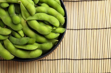 Hasır üzerinde çiğ yeşil edamame kapsülleri, üst manzara. Metin için boşluk