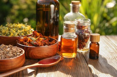 Dışarıdaki ahşap masada farklı tentürler ve malzemeler var.