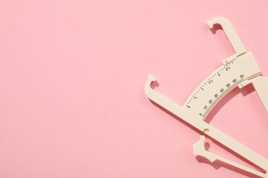 Pembe arka planda plastik vücut kalibreli, üst manzara. Metin için boşluk