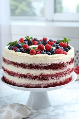 Farklı böğürtlenli lezzetli sünger kek ve beyaz mermer masada nane şekeri, yakın plan.