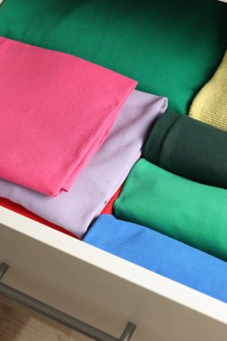 Farklı katlanmış elbiseli çekmeceler, yakın plan.