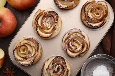 Taze pişmiş elma gülleri ve ahşap masa üzerindeki malzemeler düz. Puf böreği