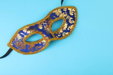 Açık mavi arka planda güzel bir karnaval maskesi, üst manzara. Metin için boşluk