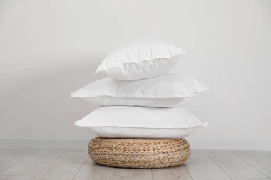 Hasır üzerinde beyaz duvarın yanında temiz yastık yığını