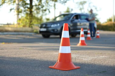 Sınavdan önce sürücü kursunda öğrenciye ders veren müfettiş, trafik konisine odaklan.