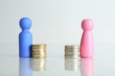 Finansal eşitsizlik. Işık masasında bozuk paraları olan erkek ve kadın figürleri