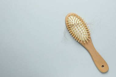 Gri arka planda saçı dökülmüş bir fırça, üst manzara. Metin için boşluk