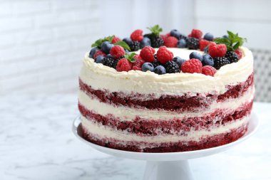 Farklı böğürtlenli lezzetli sünger kek ve beyaz mermer masada nane şekeri, yakın plan.