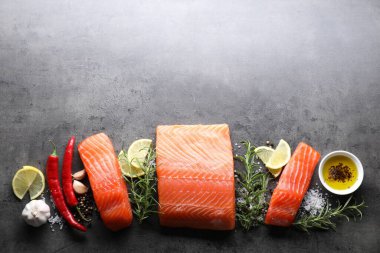 Taze somon, limon ve baharat parçaları gri masada, düz yerde. Metin için boşluk