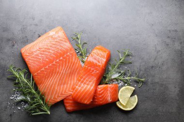 Taze somon, limon ve baharat parçaları gri masada, düz yerde. Metin için boşluk