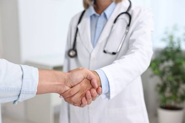 Hastanedeki hastayla el sıkışan doktor, yakın plan.