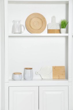 Farklı mutfak gereçleri olan beyaz raf ünitesi.