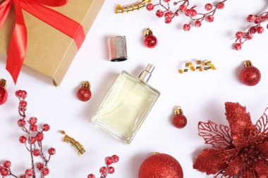 Beyaz arka planda parfüm şişesi olan Noel kompozisyonu.