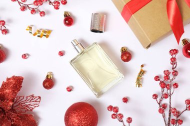 Beyaz arka planda parfüm şişesi olan Noel kompozisyonu.