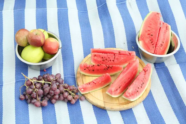 stock image Fresh watermelon, grapes and apples on blanket