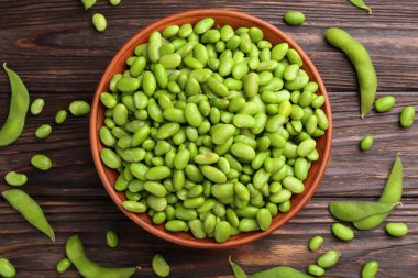 Çiğ yeşil edamame soya fasulyesi ve kapsülleri ahşap masa, düz yatıyordu.