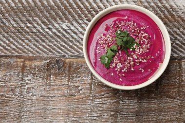 Lezzetli pancar humusu, maydanoz ve tohumlar ahşap masada, üst tarafta. Metin için boşluk