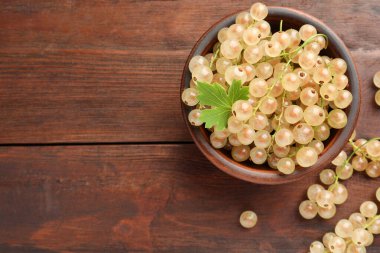 Kasede taze kuşüzümü ve ahşap masada yeşil yaprak, üst manzara. Metin için boşluk