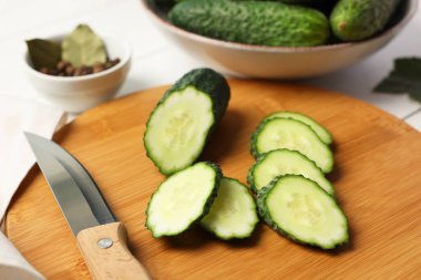 Taze kesilmiş salatalık ve bıçak beyaz masada, yakın plan.