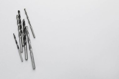 Açık gri arkaplanda birçok farklı matkap ucu, üst görünüm. Metin için boşluk