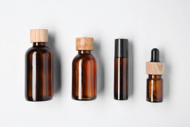 Temel yağlar hafif arka planda şişelerde, düz yerde.