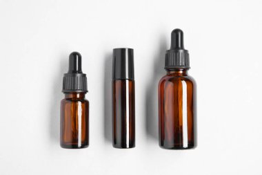 Temel yağlar hafif arka planda şişelerde, düz yerde.